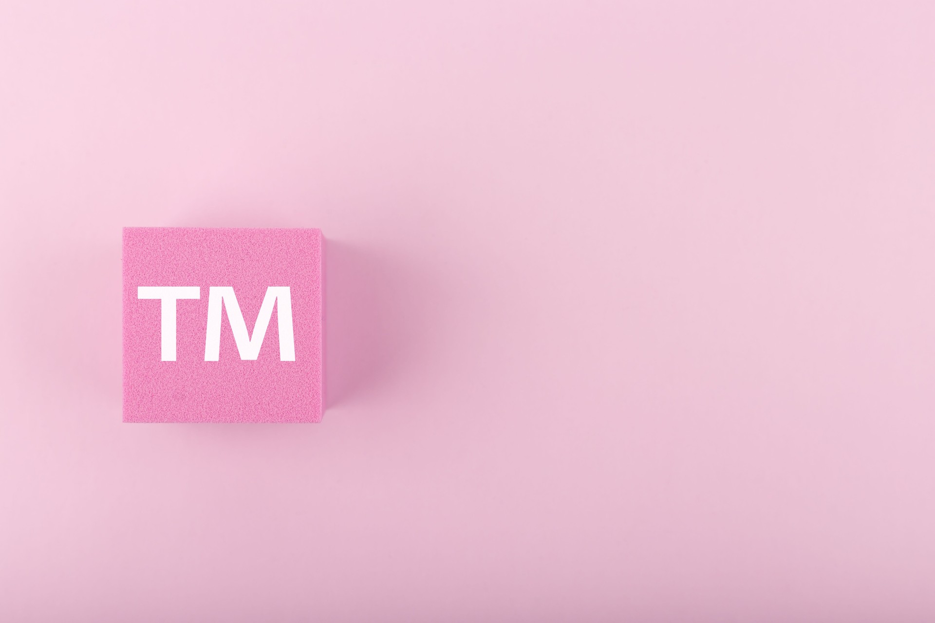 TM trademark sign on pink figure on bright pink background with copy space
