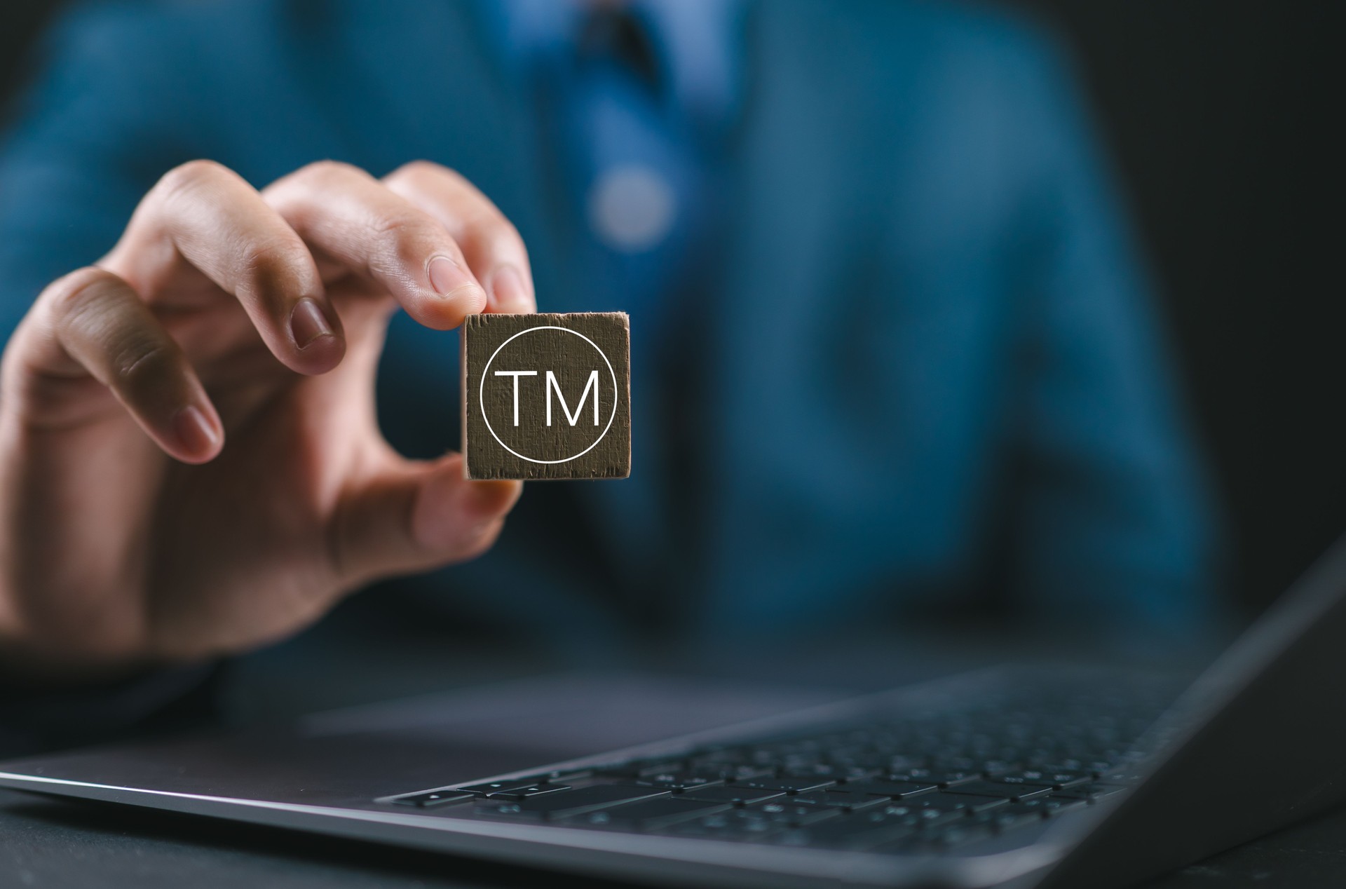 Registration or registration for trademark concept, copyright protection. Businessman holding wooden block with register trademark logo.